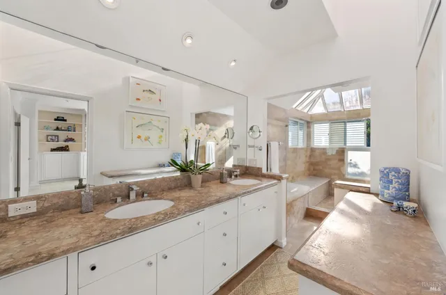 a spacious bathroom with double sink and a mirror