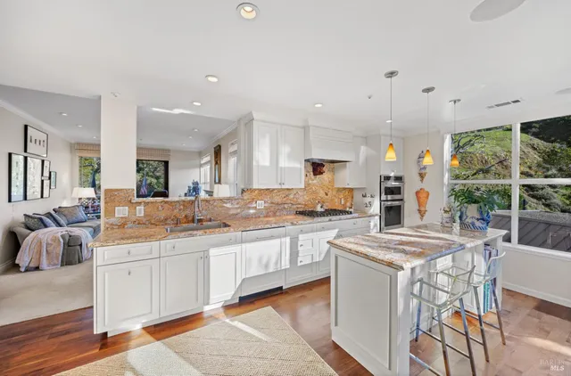 a large kitchen with kitchen island a sink a stove a dining table and chairs
