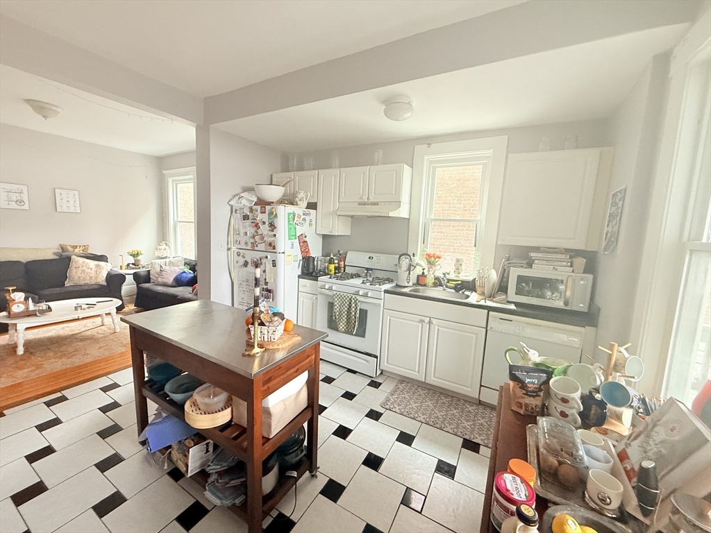 15 Chester Street, Unit 4 Boston, MA 02134 - Photo 18 of 20 a kitchen with stainless steel appliances a sink a stove a dining table and chairs