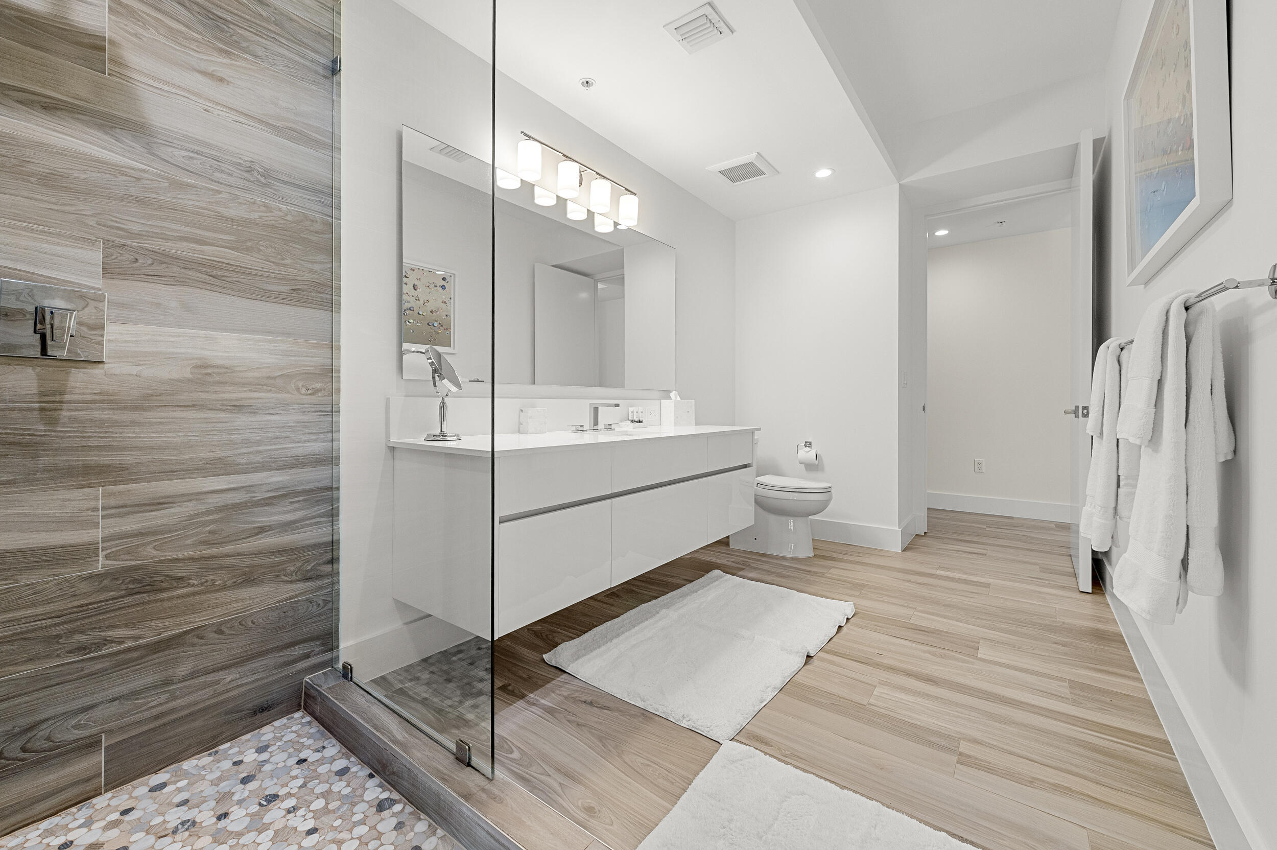 106 Inlet Way, Unit 103 Singer Island, FL 33404 - Photo 22 of 29 a en suite bathroom with a double vanity sink a toilet and a mirror