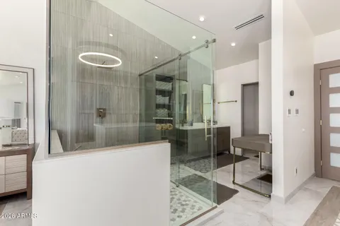 a bathroom with a tub a mirror and a shower