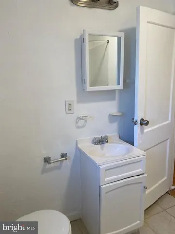 a bathroom with a granite countertop toilet sink and mirror