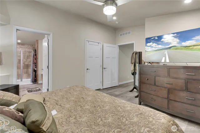 a spacious bedroom with a bed and a dresser