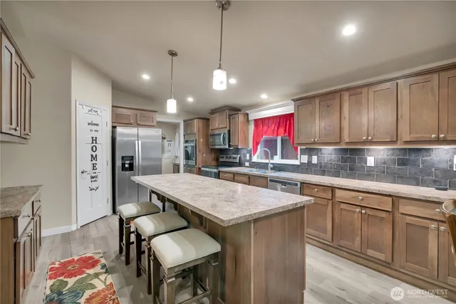 a kitchen with stainless steel appliances granite countertop a sink refrigerator and cabinets
