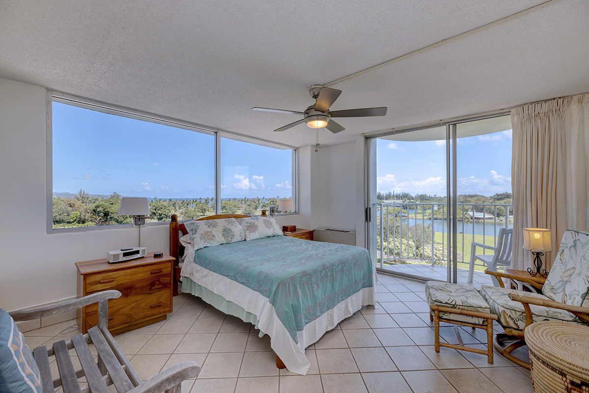 101 Aupuni Street, Unit 802 Hilo, HI 96720 - Photo 2 of 29 a bedroom with a bed and large windows