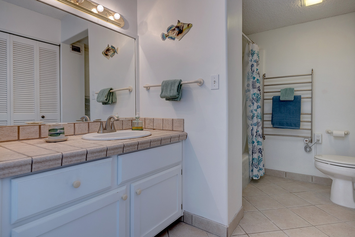 101 Aupuni Street, Unit 802 Hilo, HI 96720 - Photo 9 of 29 a bathroom with a toilet sink and mirror