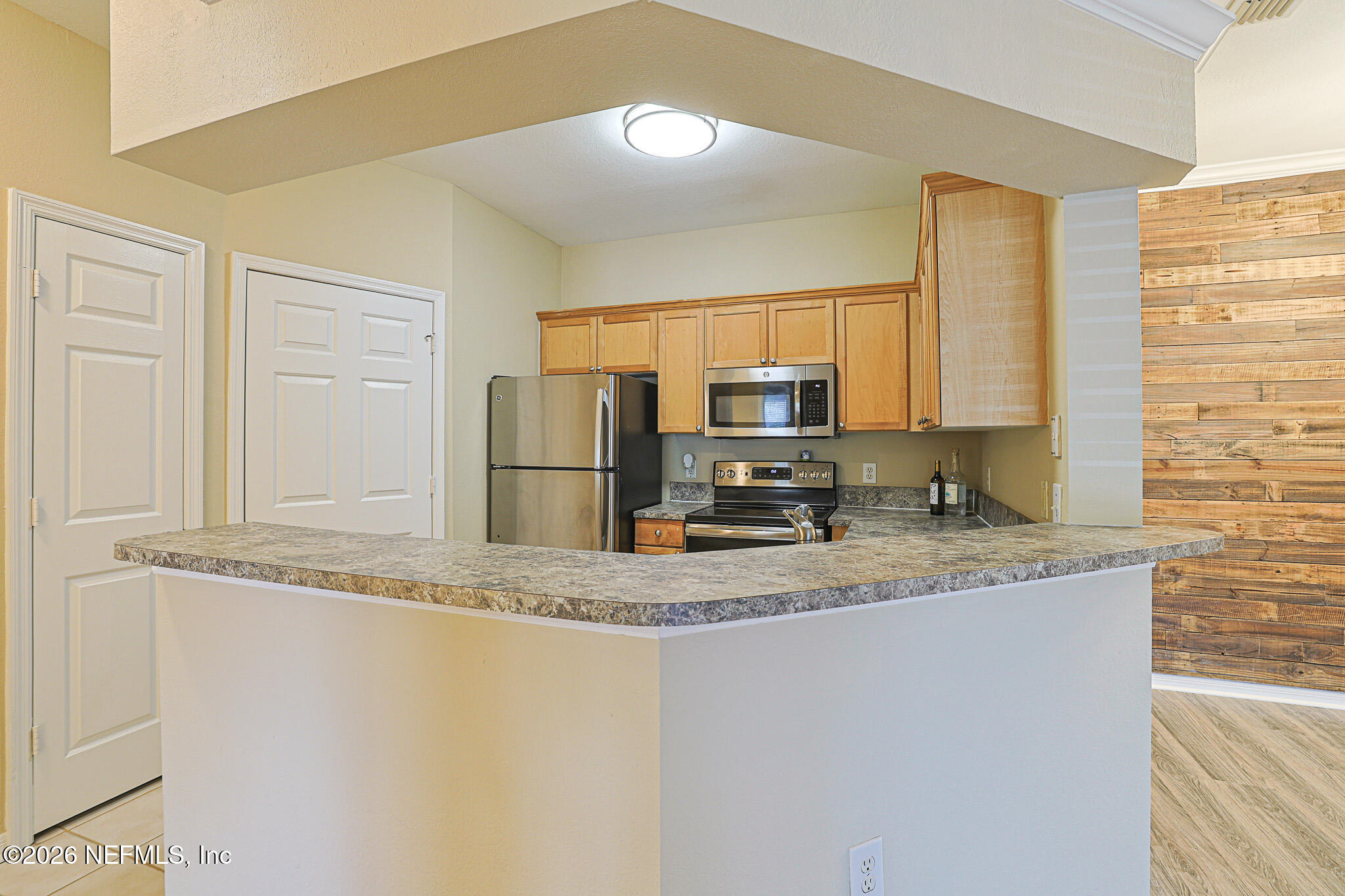 10961 Burnt Mill Road, Unit 426 Jacksonville, FL 32256 - Photo 7 of 24 a kitchen with stainless steel appliances granite countertop a sink refrigerator and microwave