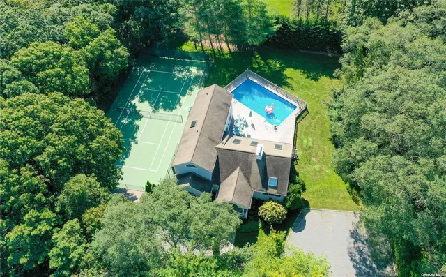 an aerial view of a house with swimming pool a yard and outdoor seating