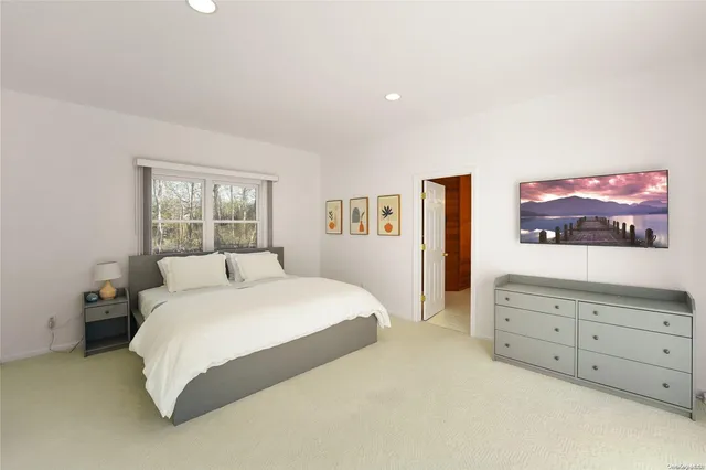 a spacious bedroom with a large bed and a dresser