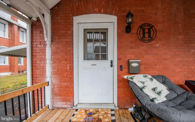 a front view of house with yard and ocean