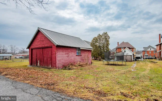 a view of a house with a big yard and large tree