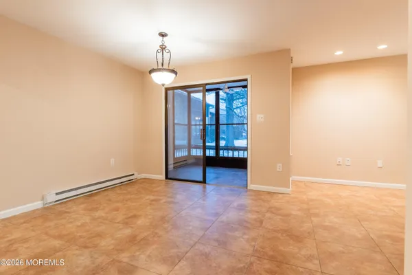 an empty room with chandelier fan and windows