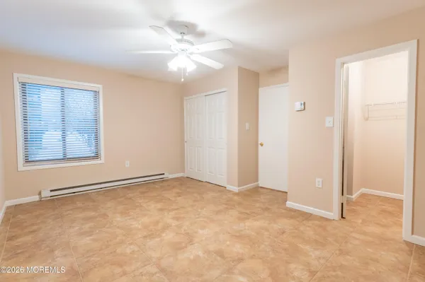 an empty room with windows and fan