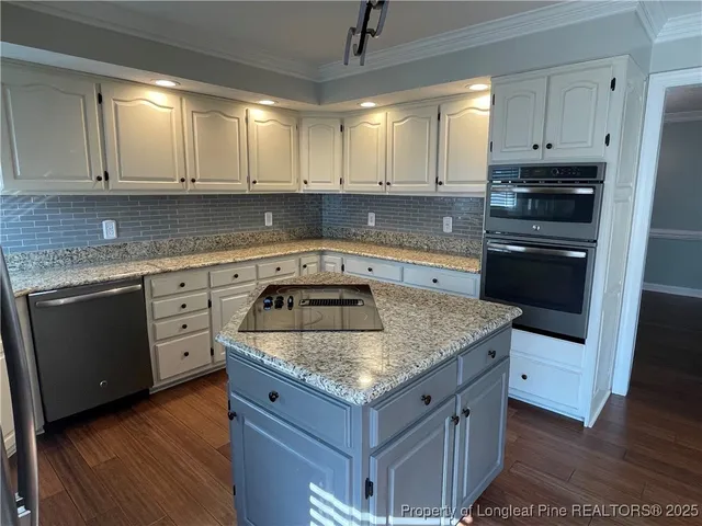 a kitchen with granite countertop a sink stove and cabinets