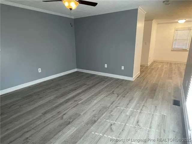 a view of an empty room with wooden floor