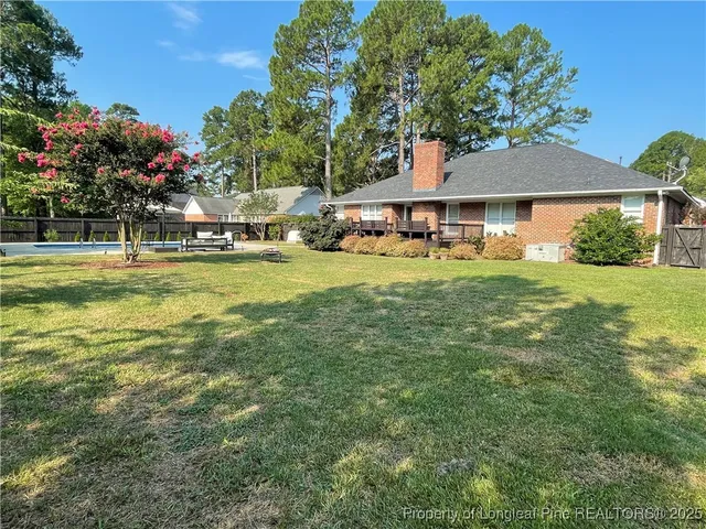 a view of a house with a big yard and palm trees