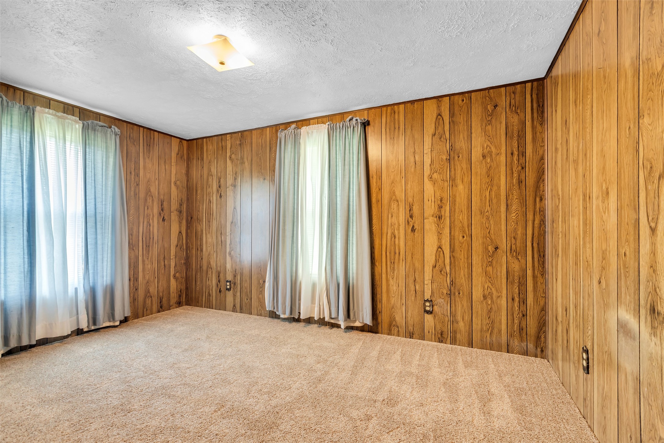 302 Channelview Drive Anahuac, TX 77514 - Photo 24 of 35 an empty room with a wooden walls and curtain