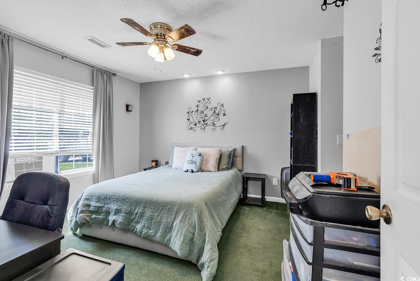 9450 Leeds Circle Myrtle Beach, SC 29588 - Photo 12 of 25 Carpeted bedroom featuring ceiling fan, a textured ceiling, baseboards, and visible vents