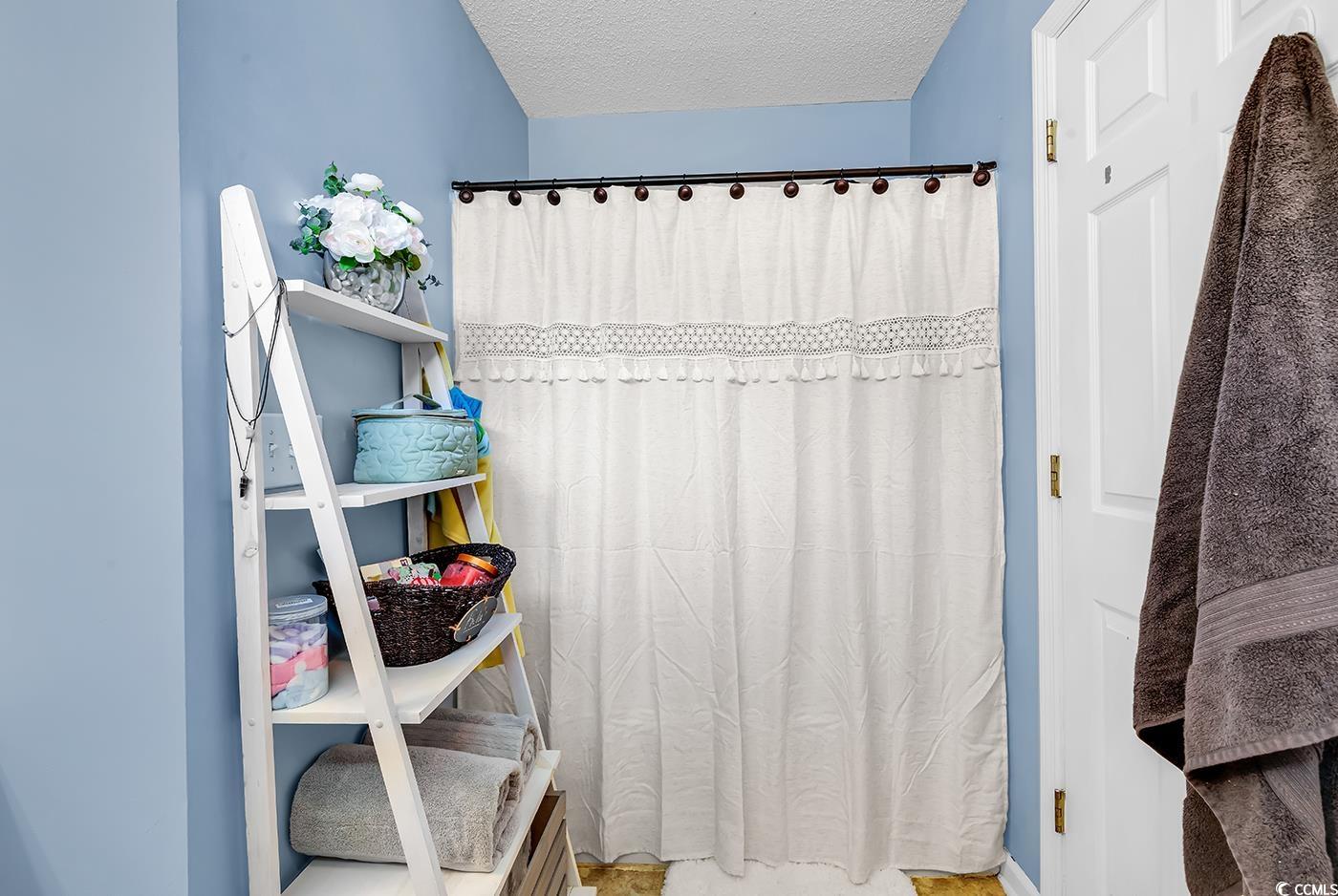 9450 Leeds Circle Myrtle Beach, SC 29588 - Photo 16 of 25 Bathroom featuring a textured ceiling and curtained shower