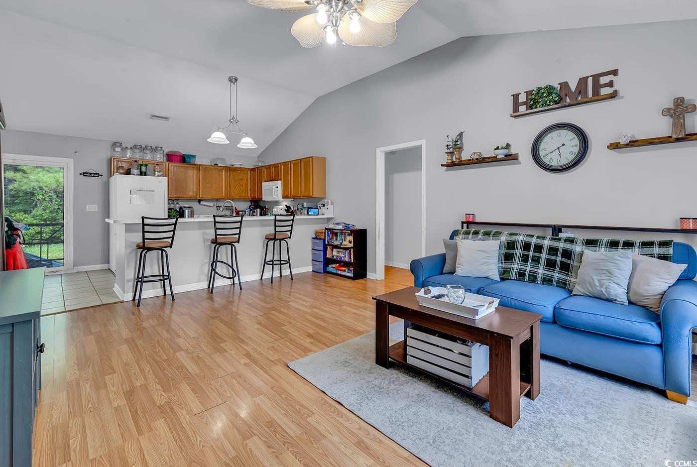 9450 Leeds Circle Myrtle Beach, SC 29588 - Photo 2 of 25 Living room featuring visible vents, baseboards, ceiling fan, light wood-style floors, and vaulted ceiling
