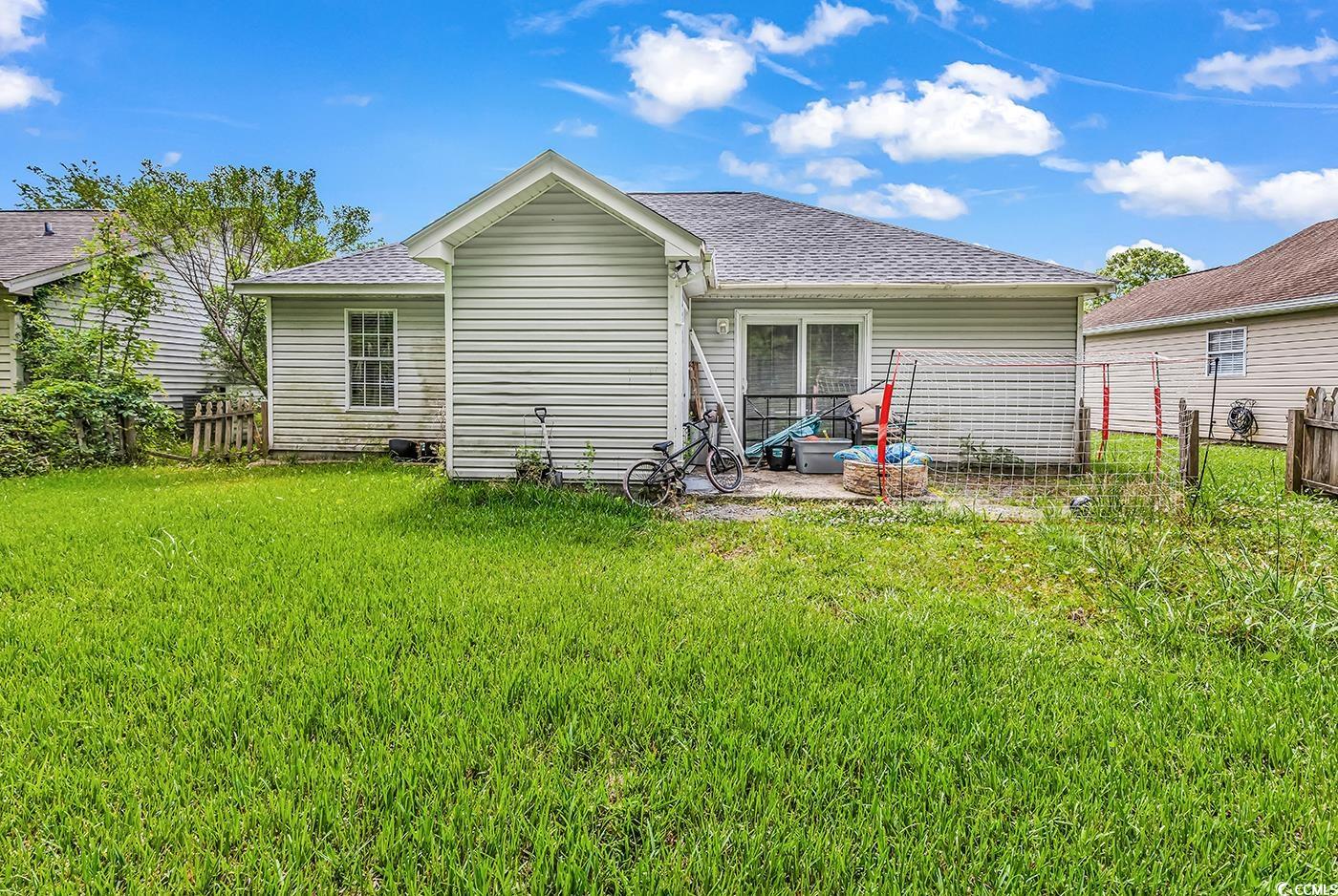 9450 Leeds Circle Myrtle Beach, SC 29588 - Photo 22 of 25 Back of property featuring a yard, fence, a shingled roof, and a patio