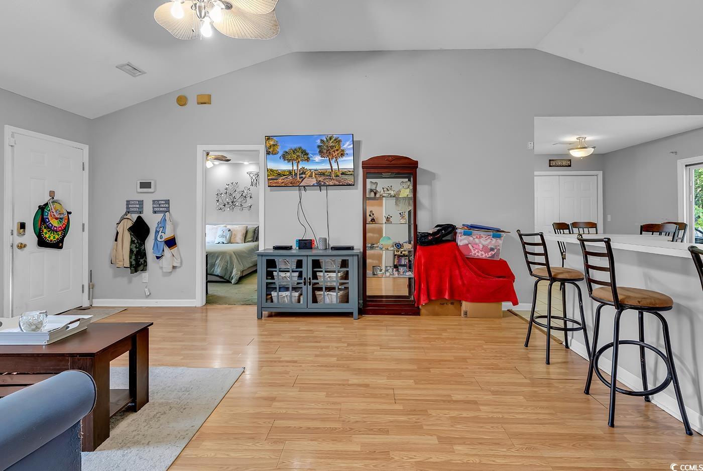 9450 Leeds Circle Myrtle Beach, SC 29588 - Photo 5 of 25 Living area featuring light wood finished floors, a ceiling fan, visible vents, and lofted ceiling