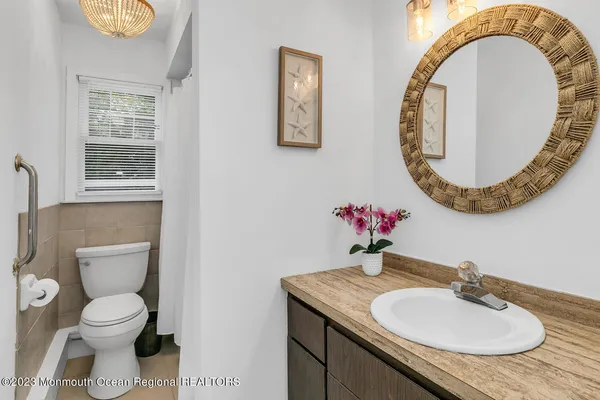 a bathroom with a toilet sink mirror and vanity