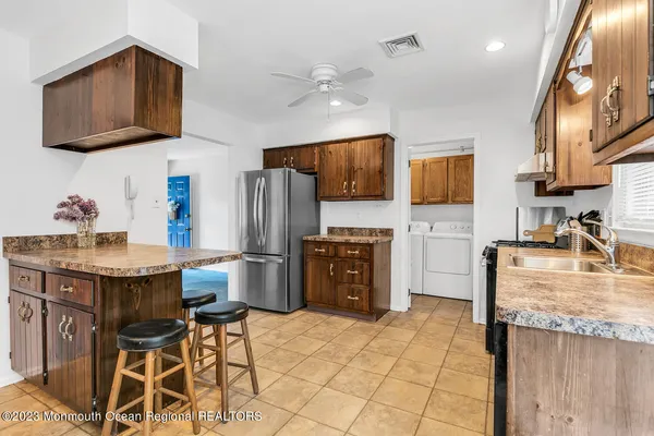 a kitchen with stainless steel appliances granite countertop a refrigerator and a stove top oven