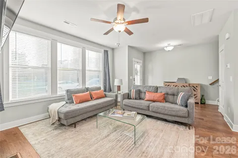 a living room with furniture a fireplace and wooden floor