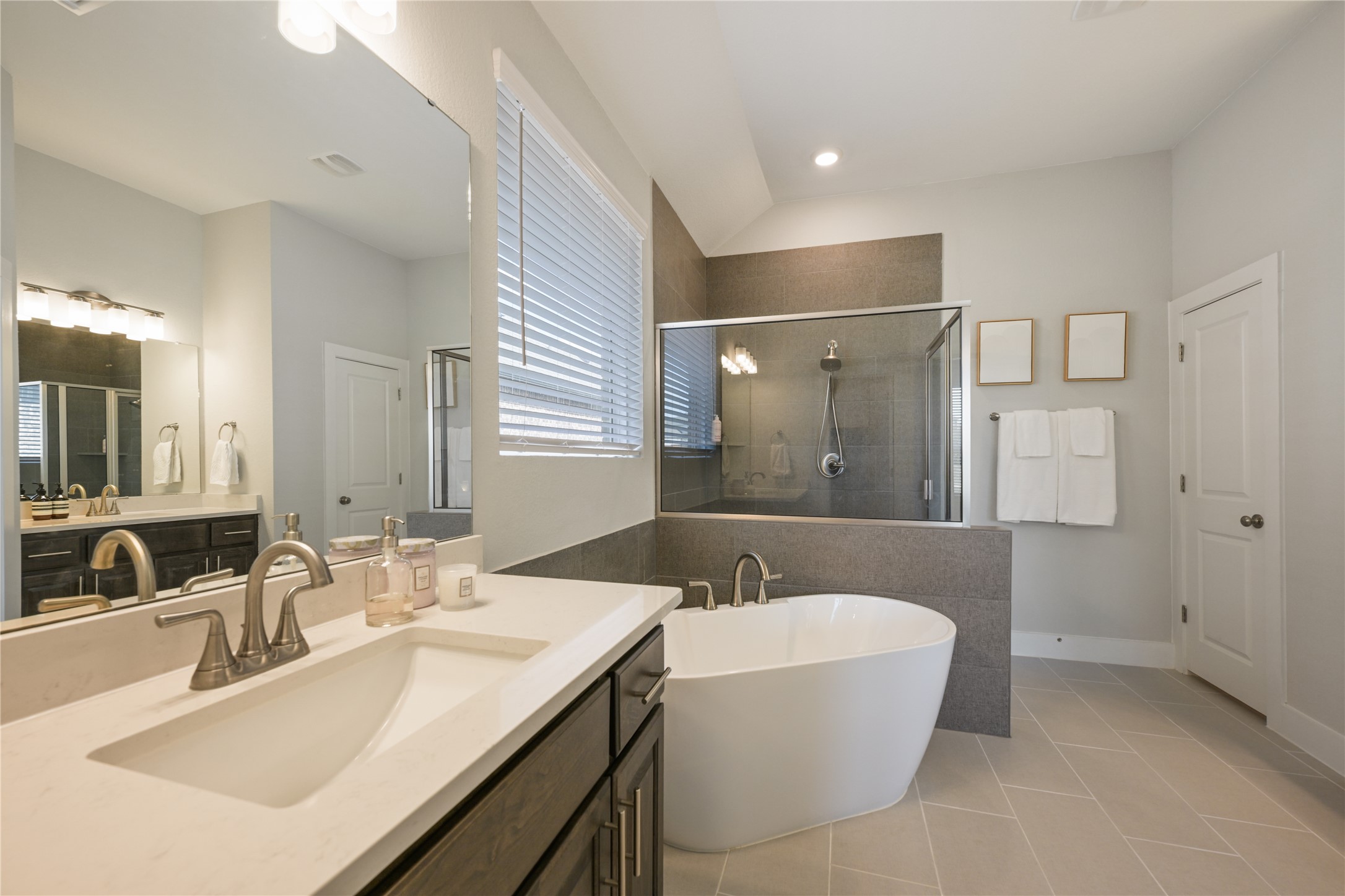 238 Wild Pecan Loop Buda, TX 78610 - Photo 16 of 31 A freestanding tub and walk-in shower elevate this tiled bathroom with high ceilings.