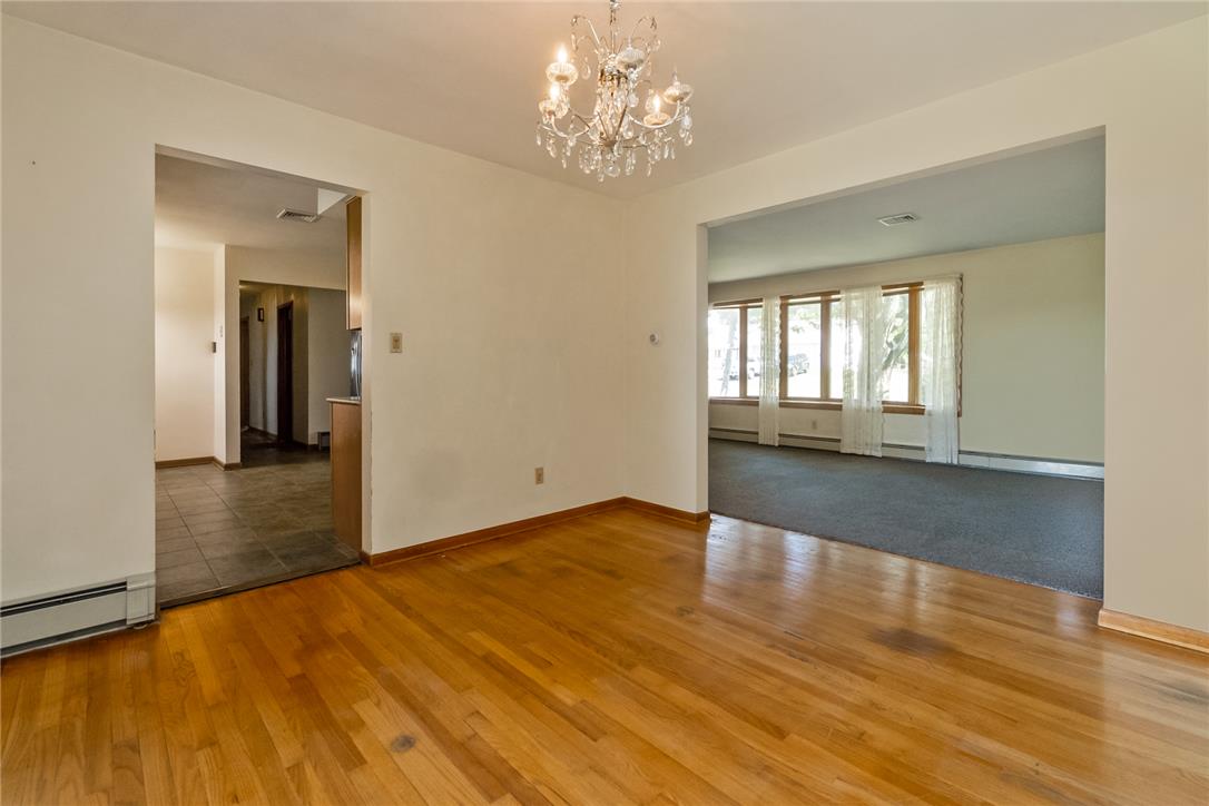 1657 Clearview Road Coplay, PA 18037 - Photo 39 of 77 A classic chandelier illuminates this spacious interior, offering seamless transitions between rooms with gleaming hardwood and cozy carpeted floors.