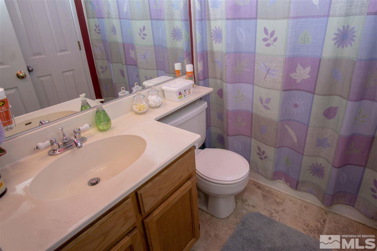 1067 Embassy Way Reno, NV 89523 - Photo 14 of 18 a bathroom with a sink a toilet and shower curtain