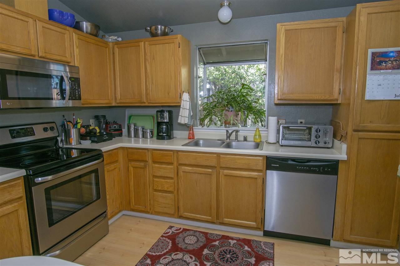 1067 Embassy Way Reno, NV 89523 - Photo 5 of 18 a kitchen with stainless steel appliances granite countertop a sink stove and microwave