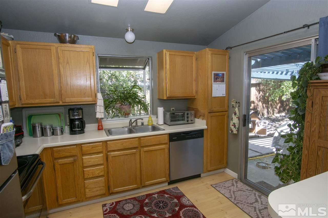 1067 Embassy Way Reno, NV 89523 - Photo 6 of 18 a kitchen with stainless steel appliances granite countertop a refrigerator a sink dishwasher and wooden cabinets