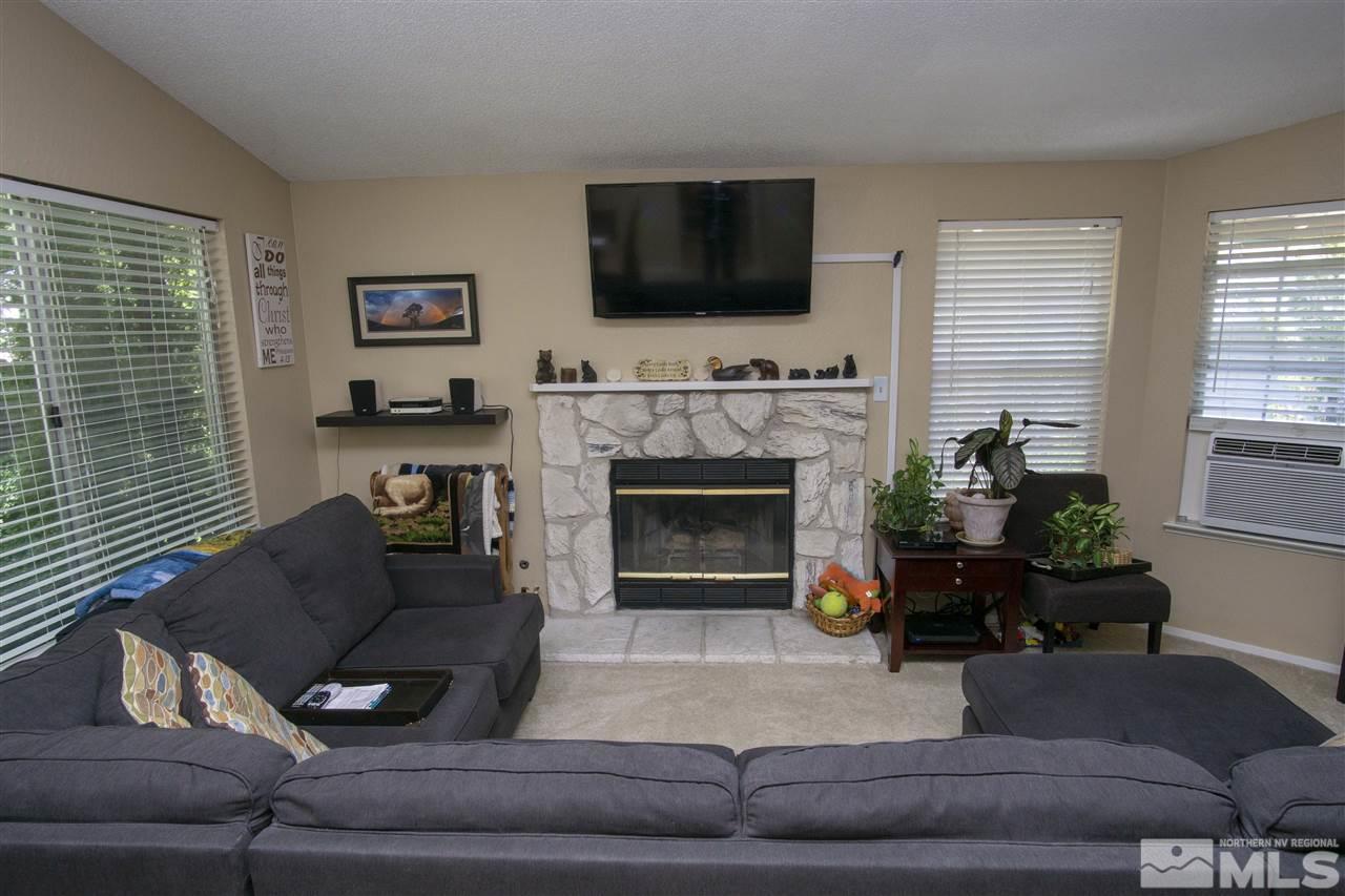 1067 Embassy Way Reno, NV 89523 - Photo 10 of 18 a living room with furniture a flat screen tv and a fireplace
