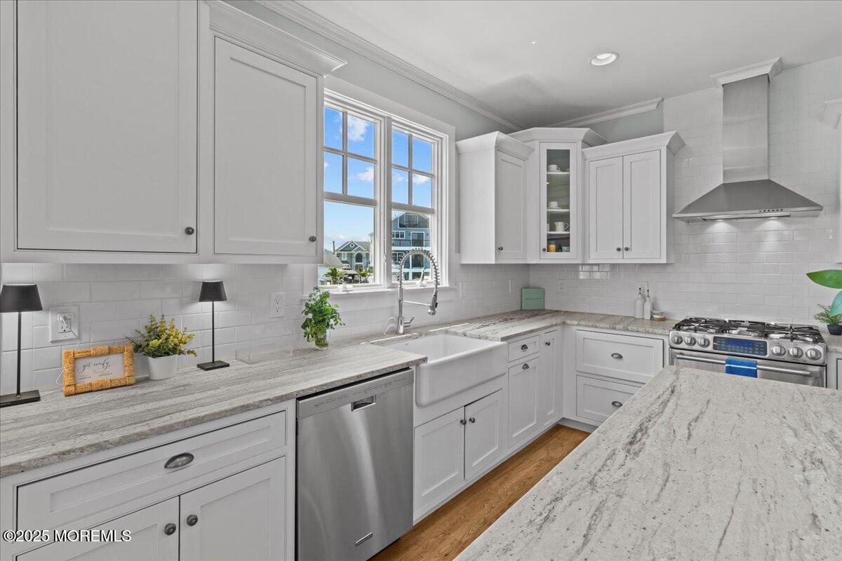 1730 Rue Mirador, Unit WINTER MONTHLY RENTAL Point Pleasant, NJ 08742 - Photo 12 of 72 a kitchen with stainless steel appliances granite countertop a stove a sink dishwasher and white cabinets with wooden floor