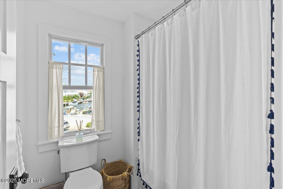 1730 Rue Mirador, Unit WINTER MONTHLY RENTAL Point Pleasant, NJ 08742 - Photo 40 of 72 a bathroom with a window a toilet and a shower
