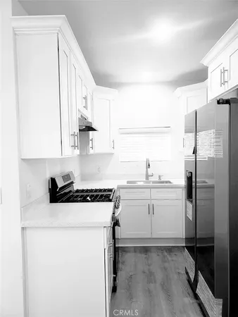 a kitchen with a sink a refrigerator and cabinets