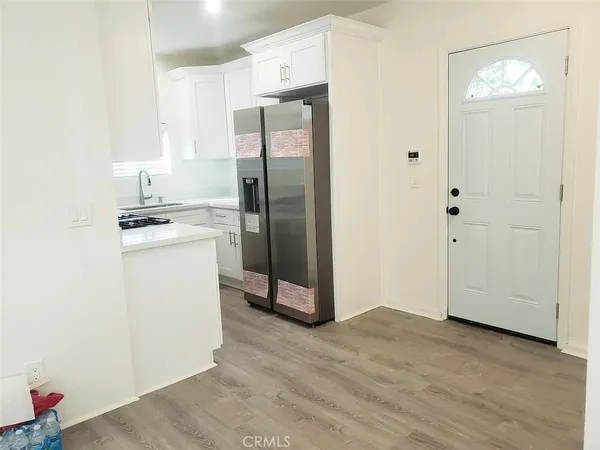 a kitchen with a refrigerator sink and cabinets