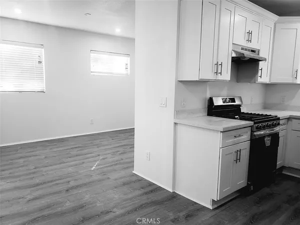 a kitchen with granite countertop white cabinets and stainless steel appliances