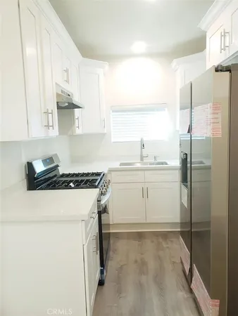 a kitchen with a stove a sink and a refrigerator