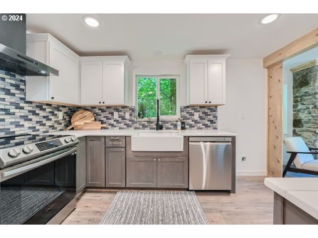 20064 South Central Point Road Oregon City, OR 97045 - Photo 11 of 34 a kitchen with white cabinets a stove a sink and a window