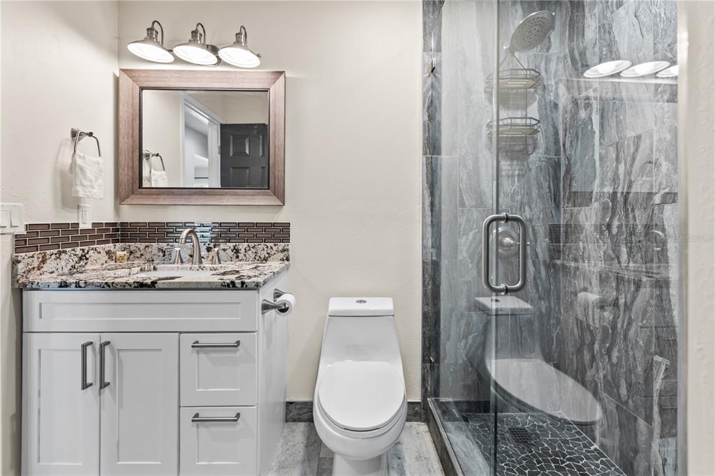 3405 Clark Road, Unit 205 Sarasota, FL 34231 - Photo 17 of 28 a bathroom with a toilet sink shower and mirror