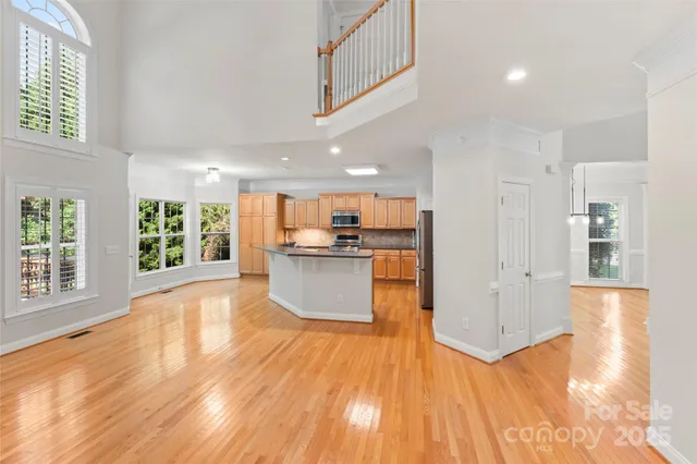 a kitchen with stainless steel appliances granite countertop a refrigerator a stove and a sink with wooden floor