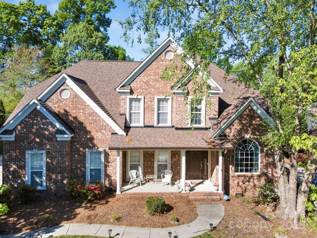 a front view of a house with yard and green space