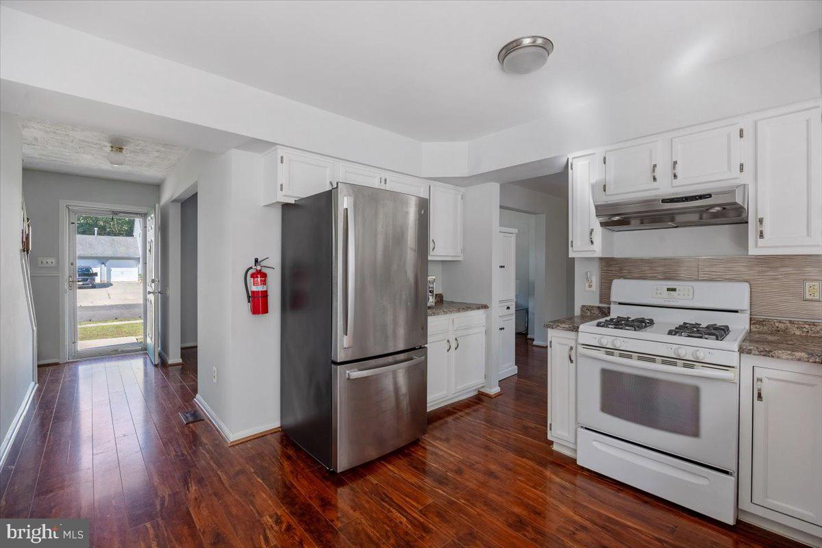 25 Country Club Road Pine Hill, NJ 08021 - Photo 7 of 40 a kitchen with a refrigerator a stove and wooden floor