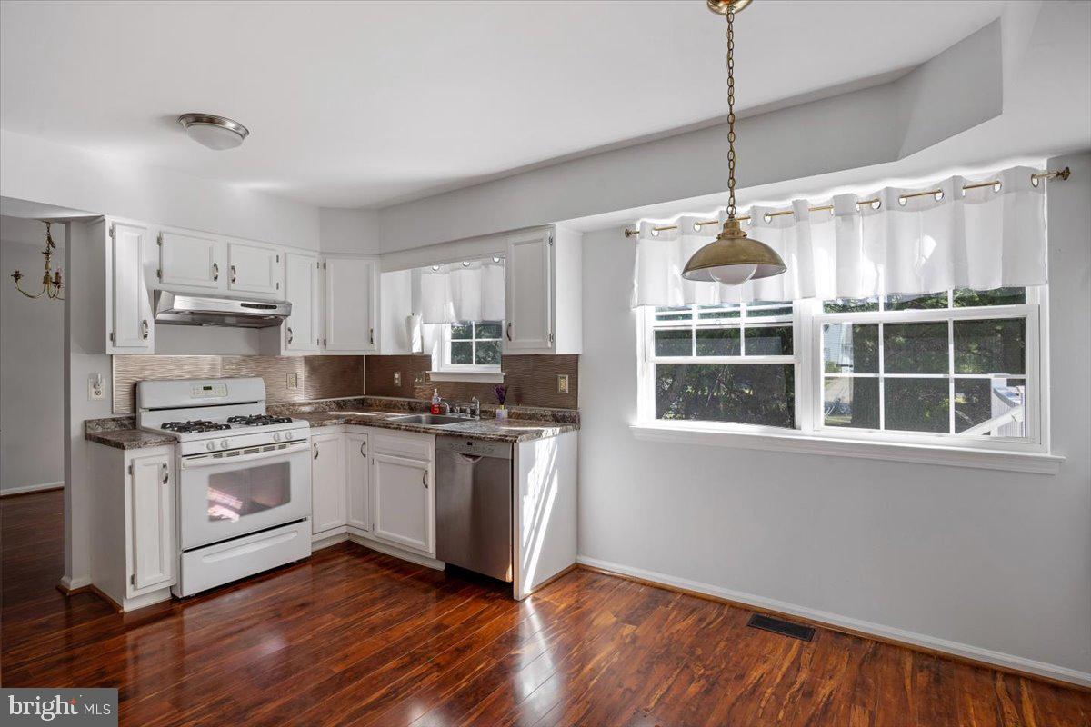 25 Country Club Road Pine Hill, NJ 08021 - Photo 10 of 40 a kitchen with stainless steel appliances granite countertop a stove a sink dishwasher a refrigerator and white cabinets with wooden floor