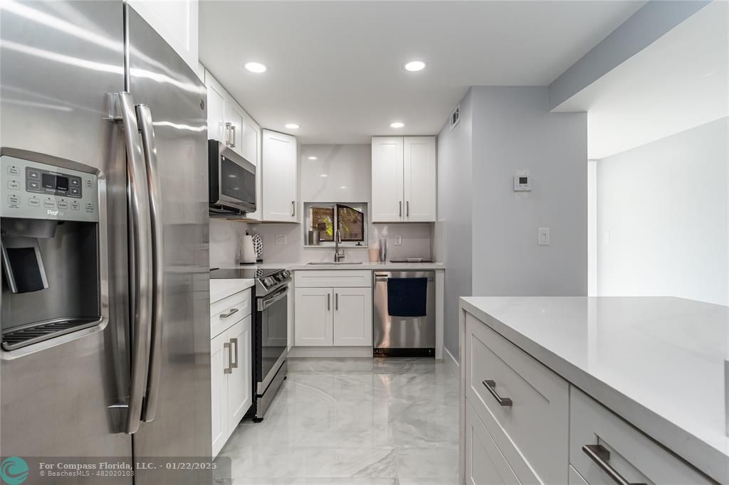 a kitchen with stainless steel appliances a refrigerator sink and microwave