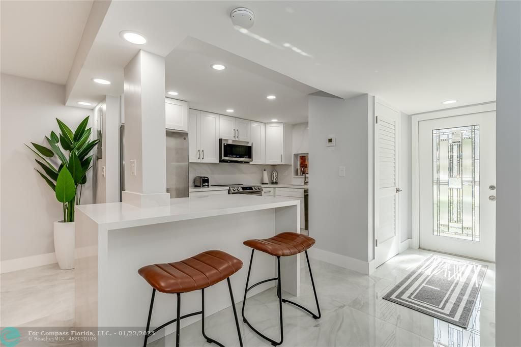 9523 South Hollybrook Lake Drive, Unit 102 Pembroke Pines, FL 33025 - Photo 11 of 63 a kitchen with stainless steel appliances kitchen island granite countertop a refrigerator and a stove top oven with white cabinets