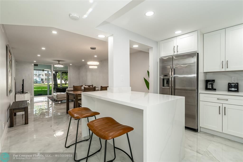 9523 South Hollybrook Lake Drive, Unit 102 Pembroke Pines, FL 33025 - Photo 12 of 63 a kitchen with stainless steel appliances kitchen island granite countertop a refrigerator and a dining table